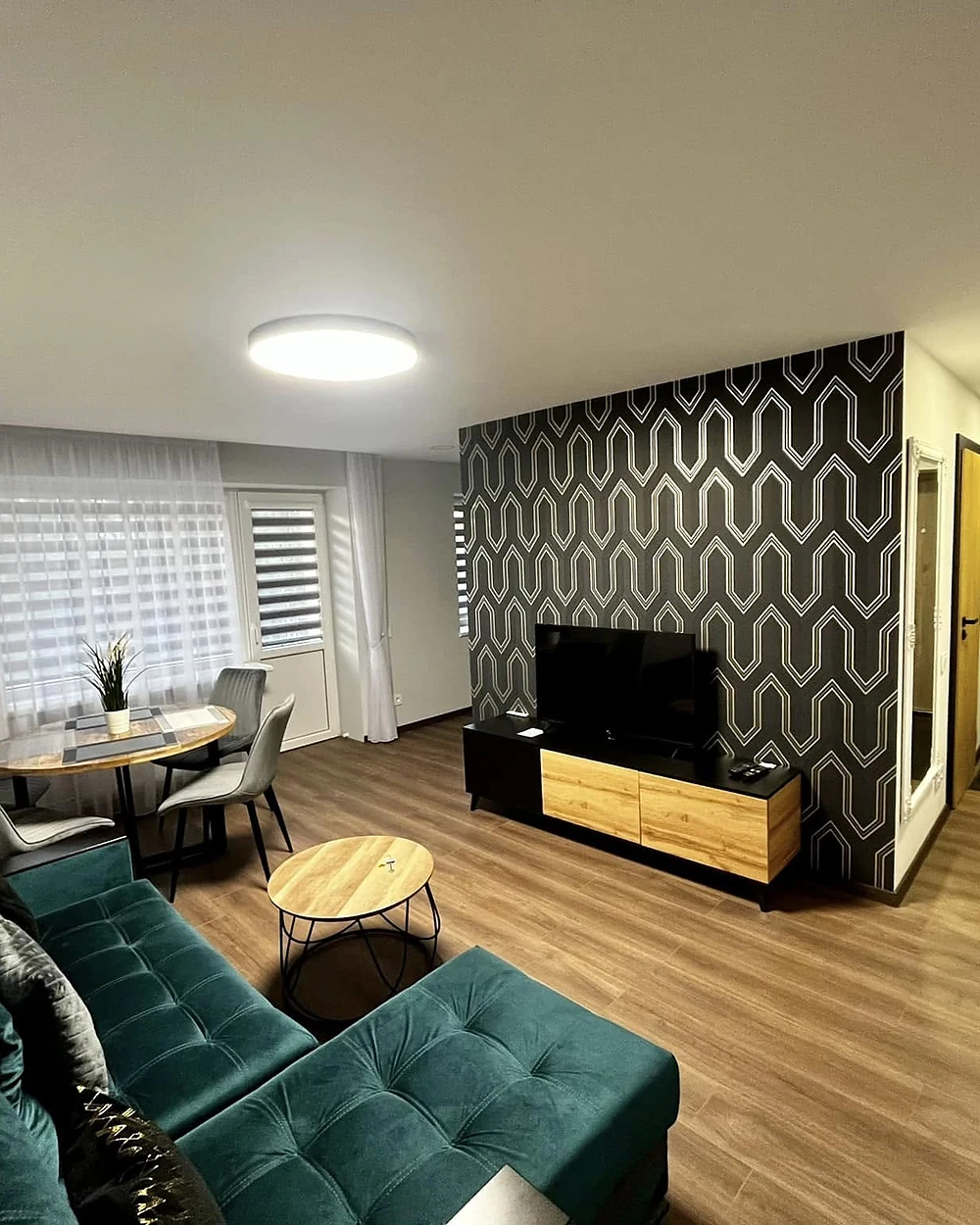 Įrengta svetainė po vidaus apdailos darbų su dekoratyvine siena ir apšvietimu
